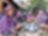 Khmer Muslim women sitting in a group peeling fruits and vegetables to be cooked.